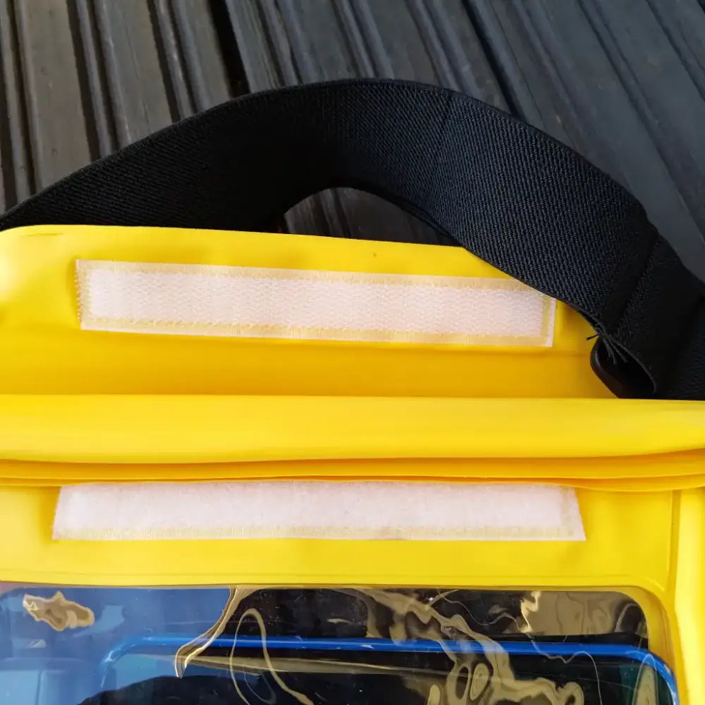 Keltainen vedenpitävä puhelintasku mustalla remmillä ja läpinäkyvällä etupaneelilla adventure waist packissa