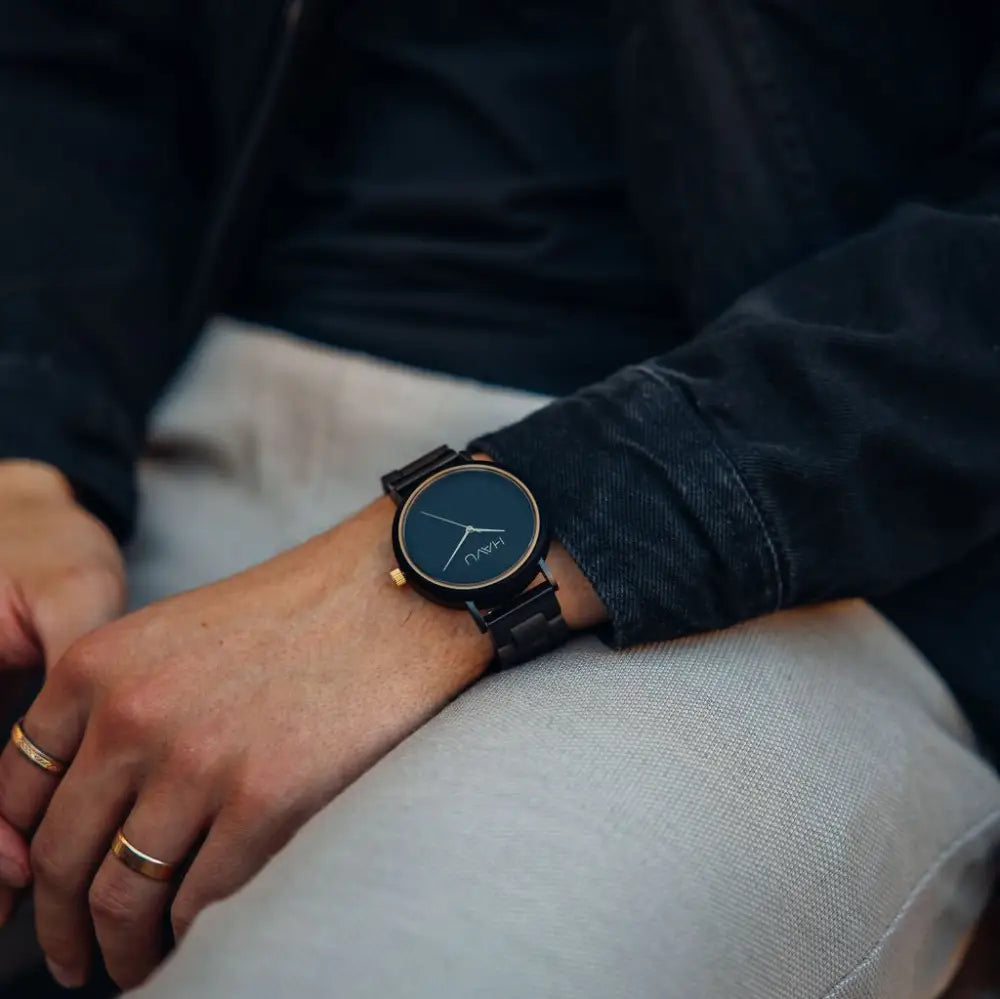 Mustaa puuta oleva aura kello 38mm, jossa on tummansininen kellotaulu ja kultahtavat yksityiskohdat