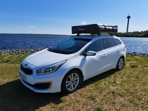 Valkoinen kia ceed farmariauto mustalla kattoboksilla auton kattoteltta ilma pitkä 1.4 harmaa takaa kuvatuna