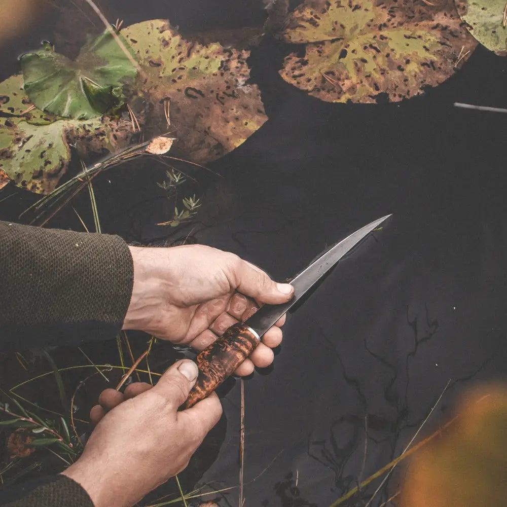 Big fillet knife jossa käsintehty tumma puukahva ja sileä metallinen terä kalastukseen
