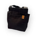 Black canvas eväskassi festival tote bag with sturdy handles and tan leather patch on front pocket
