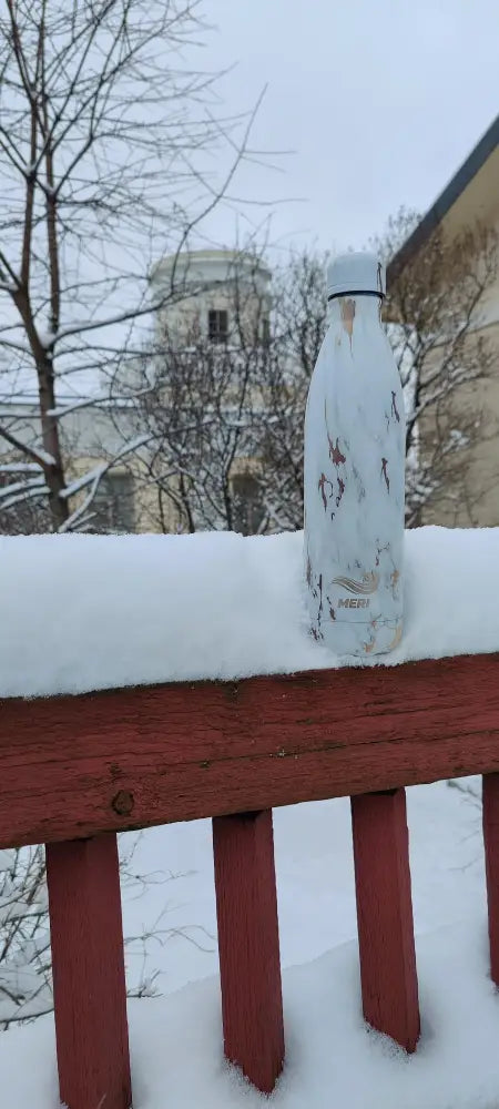 Valkoinen hieman lohjennut ruostumattomasta teräksestä valmistettu meribottles arctic gold 750 ml -juomapullo mustalla reunuksella lumisella punaisella kaiteella