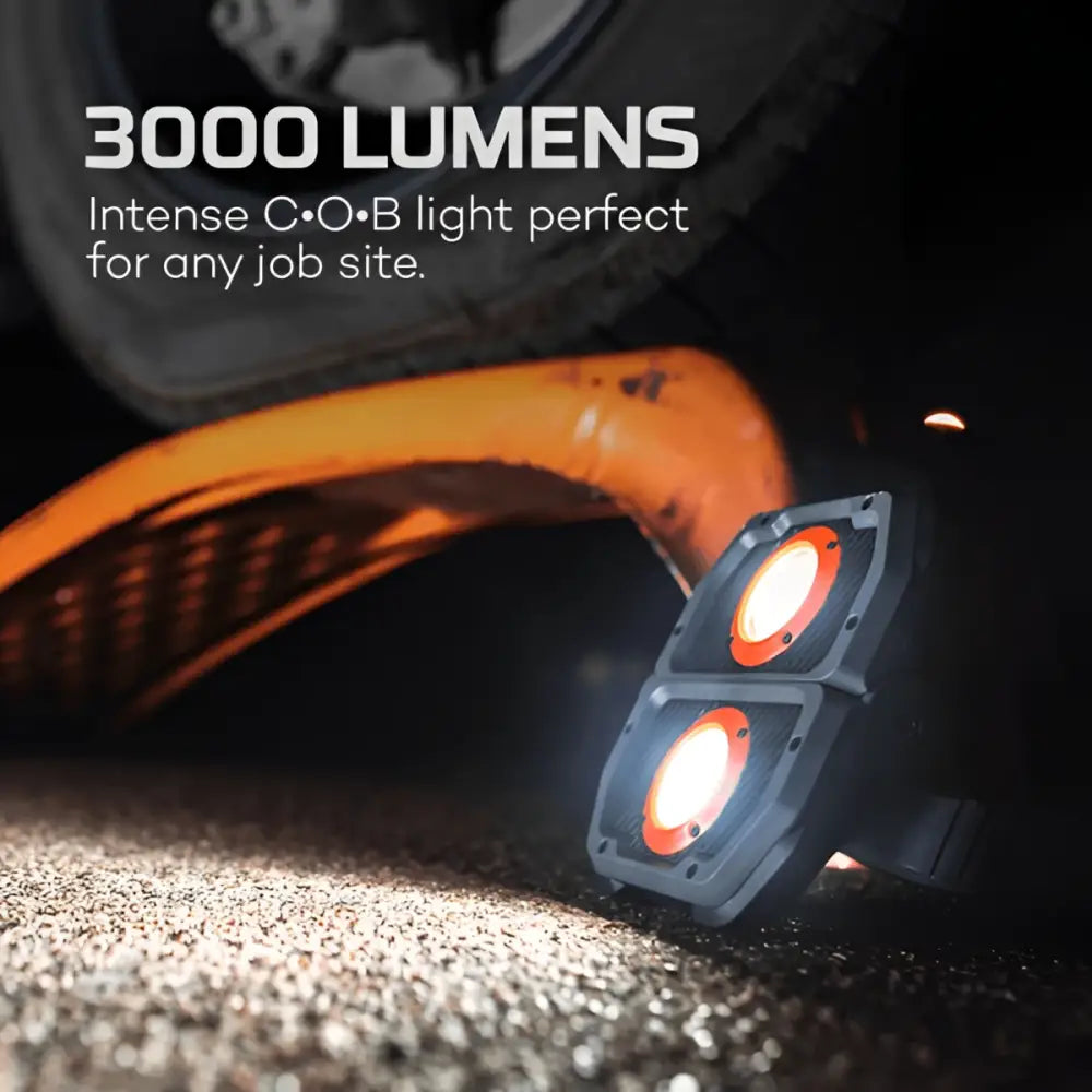 Black dual-head work light omni 3k with bright orange illuminated lenses for industrial use