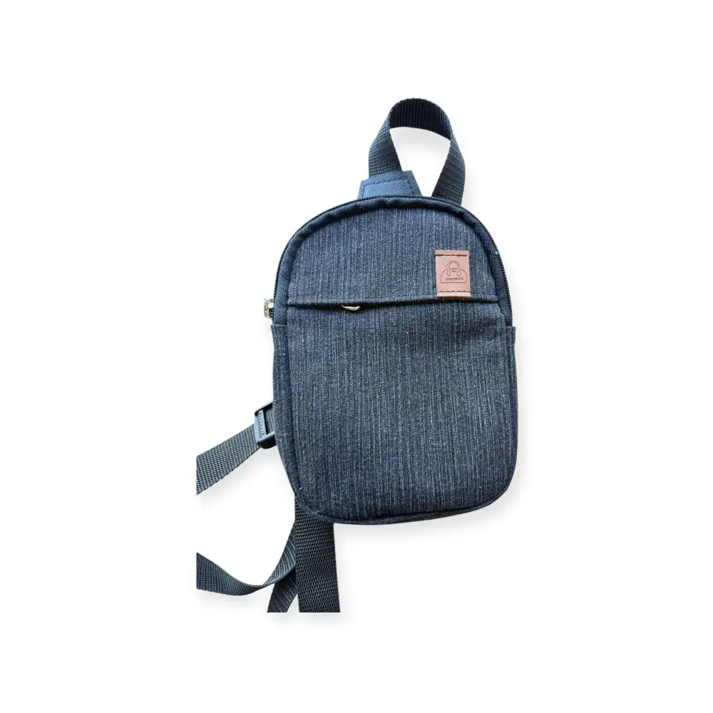 Denim-tekstuurinen laivastonsininen pikkureppu farkku ruskealla nahkapalalla ja säädettävällä hihnalla