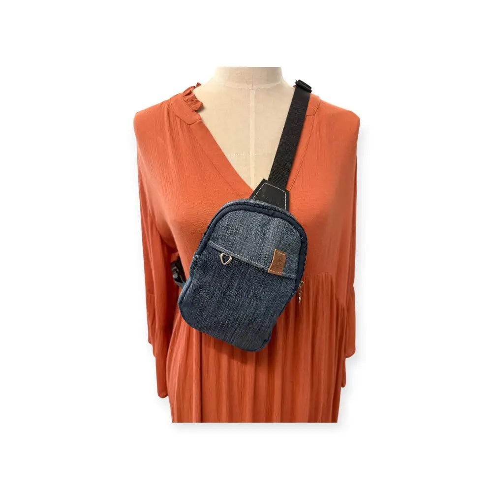 Denim-värinen pikkureppu farkku mustalla hihnalla ja ruskeilla nahka-yksityiskohdilla crossbody-laukuksi