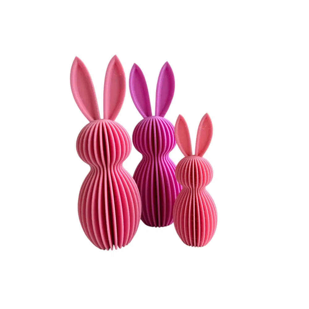 Kolme pinkkiä ja violettia ribbattua pupu koristefiguuria pitkillä korvilla kaunista kotiin