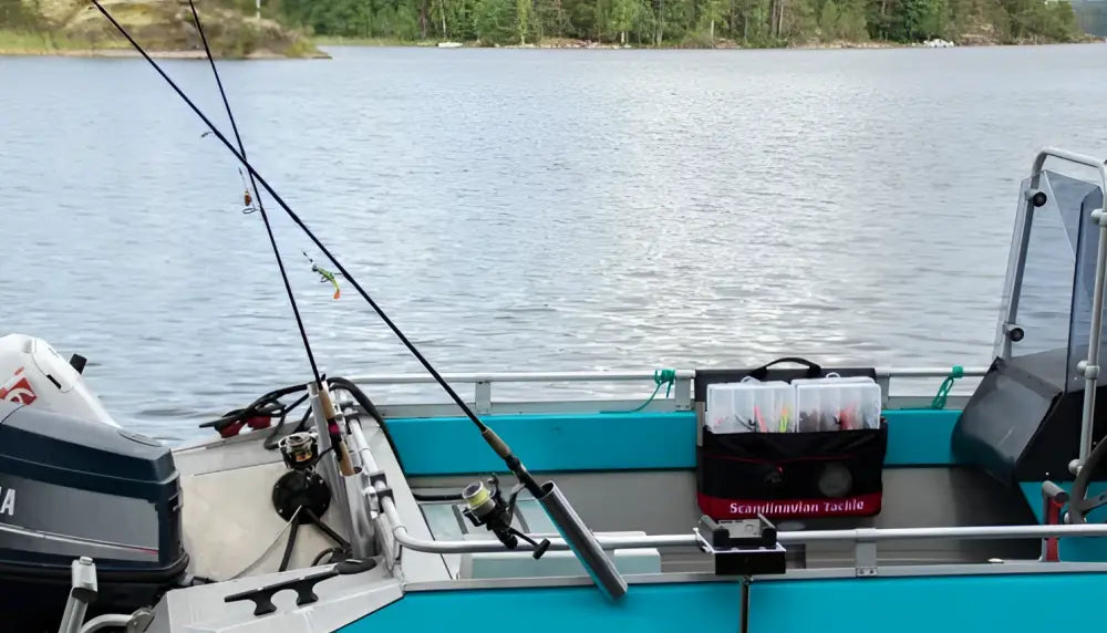 Black kalastusvavat metallikelalla lepäävät teal-värisellä veneen kannella osana scandinavian tackle jättikokoista tarvikelaukkua ja vieherasioita