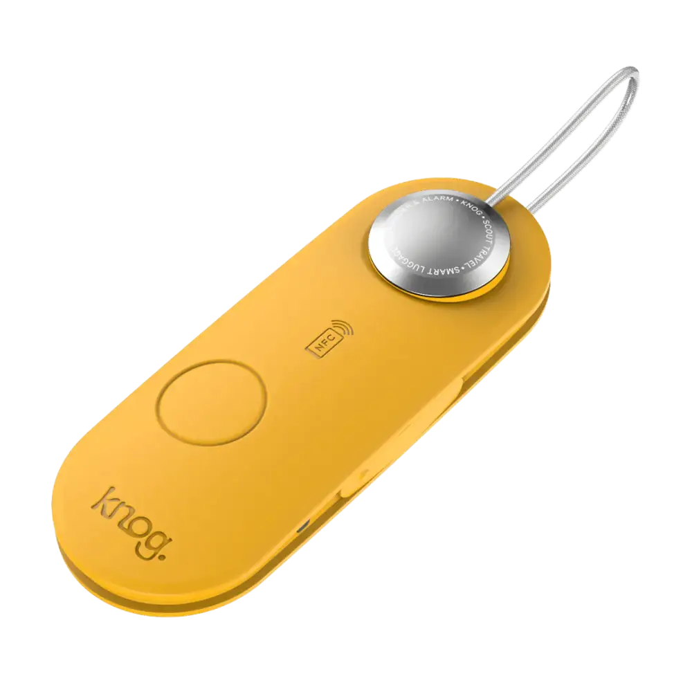 Keltainen knog scout travel älymatkalukko hopealla pyöreällä painikkeella ja kiinnitetty avainketjuun