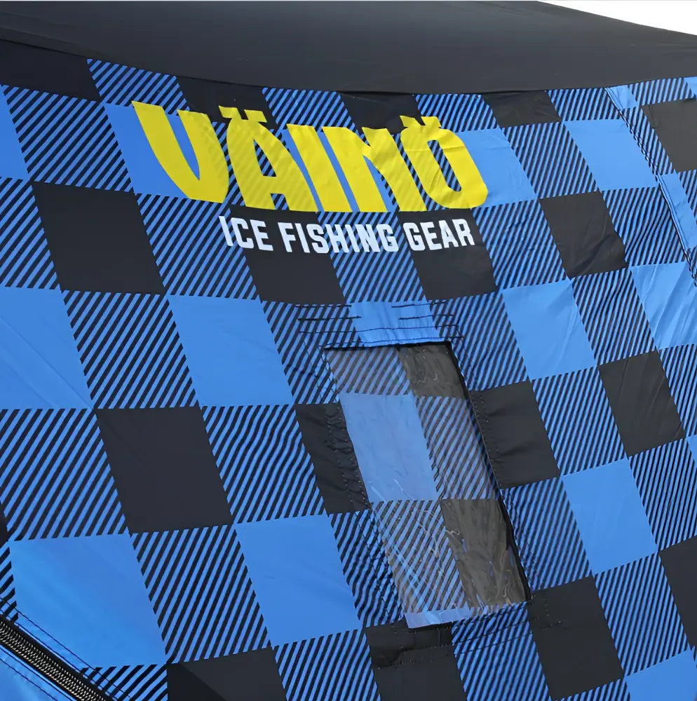 Sininen ja musta ruudullinen väinö bunker 3 glacier edition pilkkiteltta keltainen vaino-logo edessä